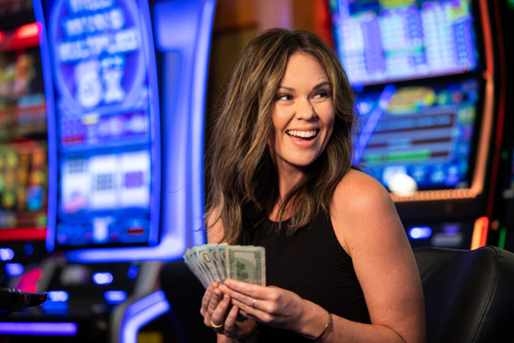 Woman holding cash in hand at Gold Country Casino Resort in Oroville, CA.