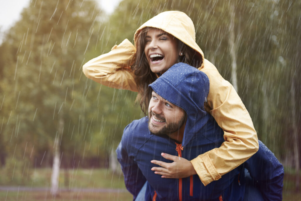 Romantic couple wearing rain jackets caught in the rain.