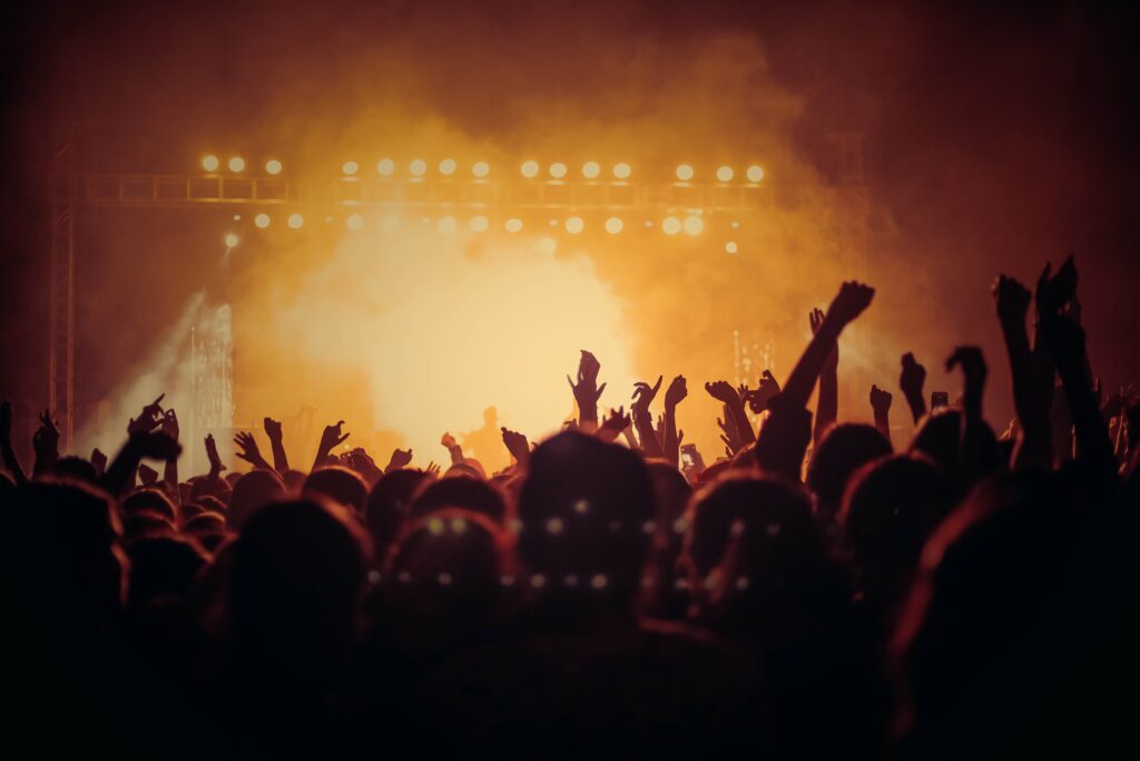 Concertgoers with their hands in the air at a concert.